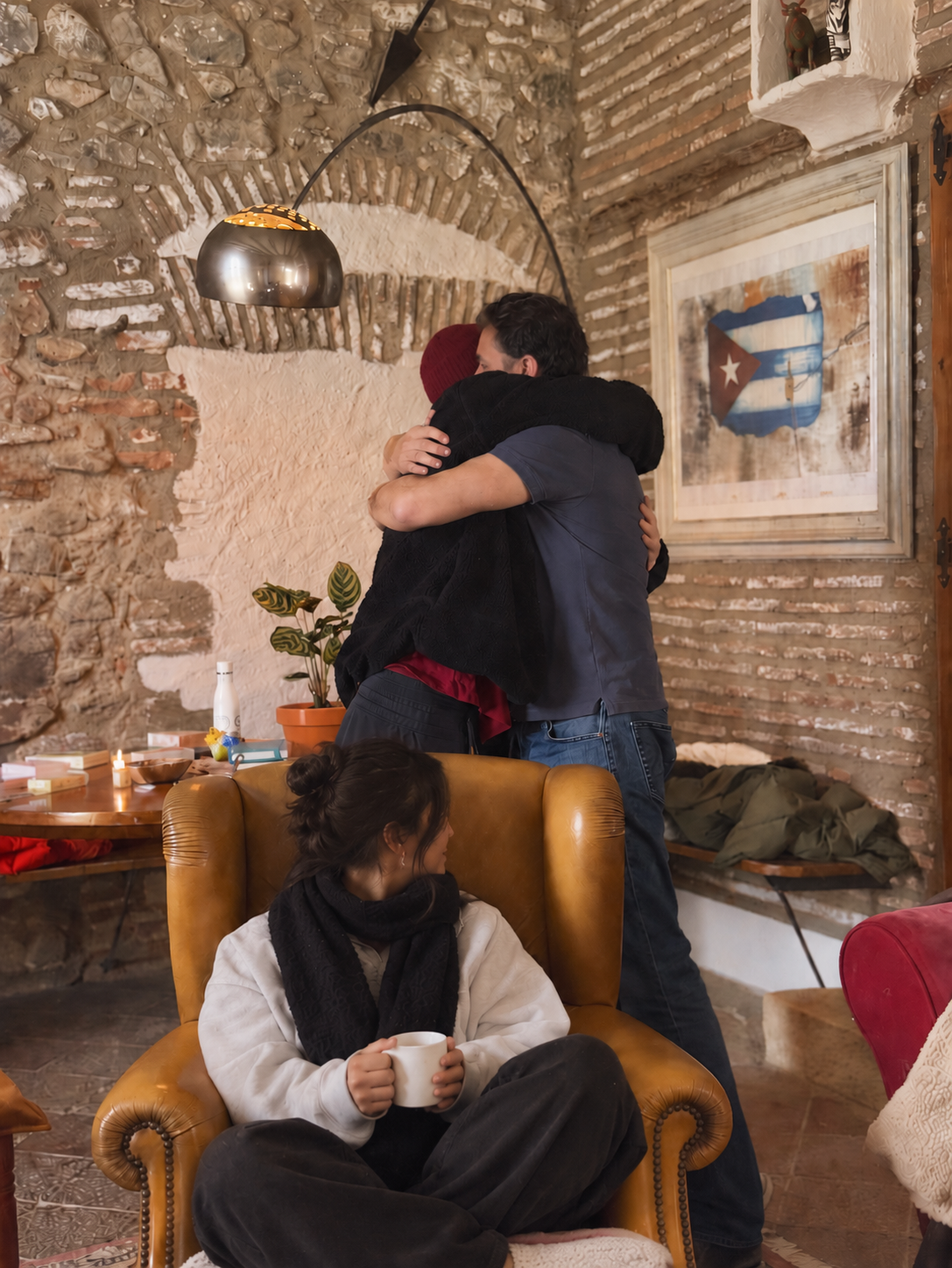 People embracing in a warm indoor space.