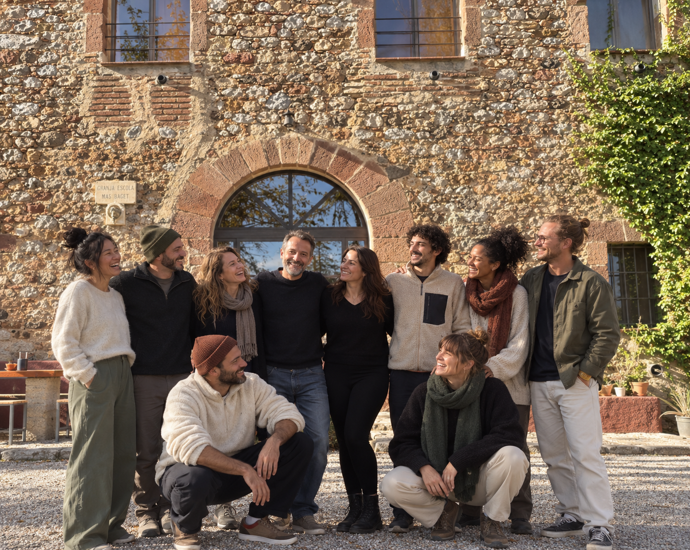 Group standing together in front of a rustic stone building.